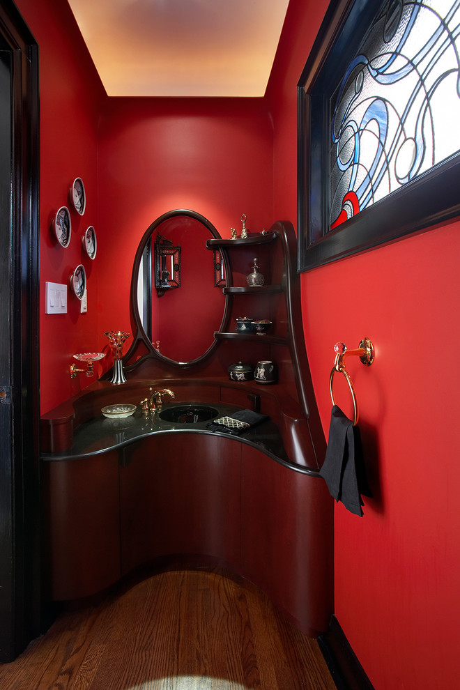 Kleine Moderne Gästetoilette mit verzierten Schränken, dunklen Holzschränken, roter Wandfarbe, braunem Holzboden, integriertem Waschbecken und Granit-Waschbecken/Waschtisch in Toronto