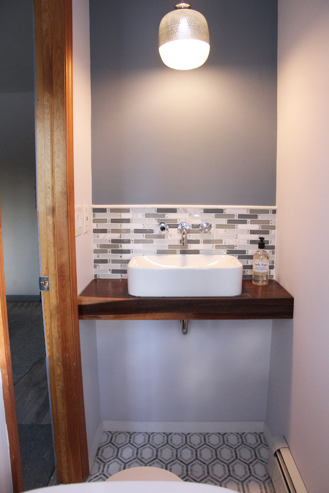 Idée de décoration pour un petit WC et toilettes champêtre avec une vasque et un plan de toilette en bois.