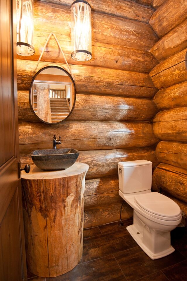 Inspiration for a mid-sized rustic dark wood floor and brown floor powder room remodel in Denver with a two-piece toilet, brown walls, a vessel sink, wood countertops and brown countertops