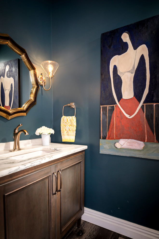 Foto di un piccolo bagno di servizio classico con ante con riquadro incassato, ante in legno bruno, pareti blu, pavimento in legno massello medio, lavabo sottopiano, top in marmo e top bianco