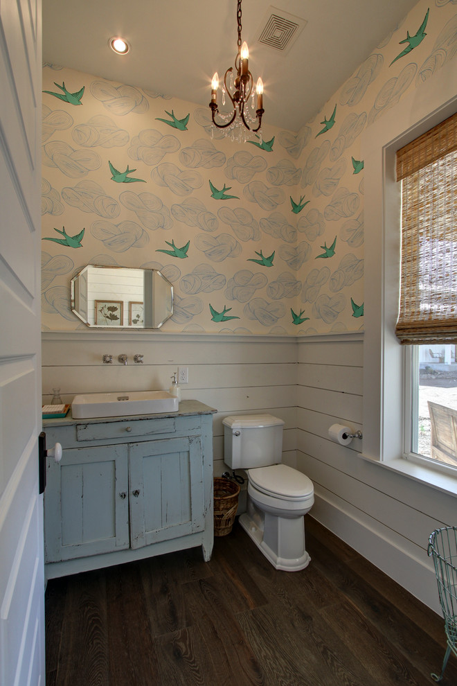 Inspiration pour un WC et toilettes rustique avec un placard en trompe-l'oeil, des portes de placard bleues, WC séparés, un mur bleu, un sol en bois brun, une vasque, un plan de toilette en bois et un plan de toilette bleu.