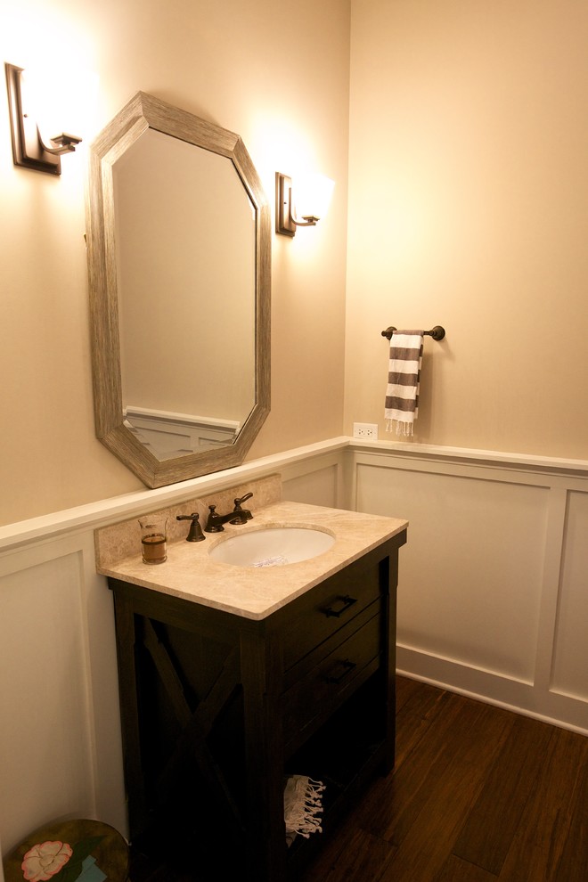 Mid-sized country medium tone wood floor and brown floor powder room photo in Chicago with shaker cabinets, granite countertops, beige countertops, a two-piece toilet, beige walls, a drop-in sink and black cabinets