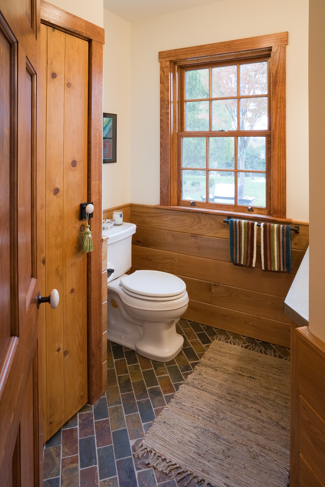 На фото: туалет в стиле кантри с белыми стенами, полом из сланца и раздельным унитазом с