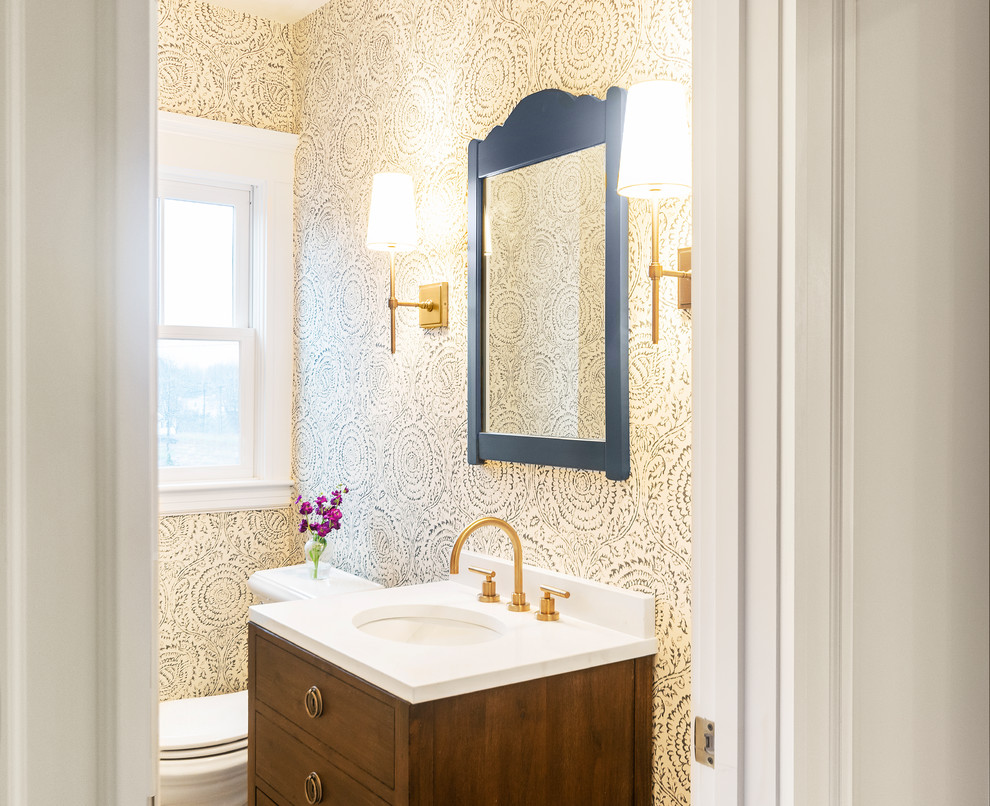 Klassische Gästetoilette mit flächenbündigen Schrankfronten, hellbraunen Holzschränken, beiger Wandfarbe, Unterbauwaschbecken und weißer Waschtischplatte in Boston