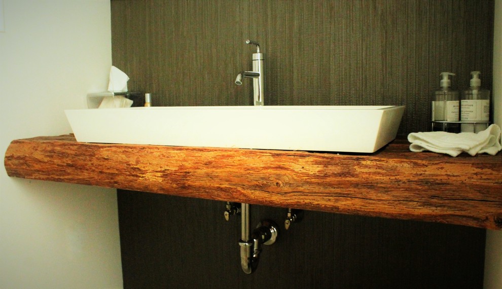Esempio di un bagno di servizio rustico di medie dimensioni con pareti beige, lavabo a bacinella, top in legno, piastrelle nere e piastrelle in gres porcellanato
