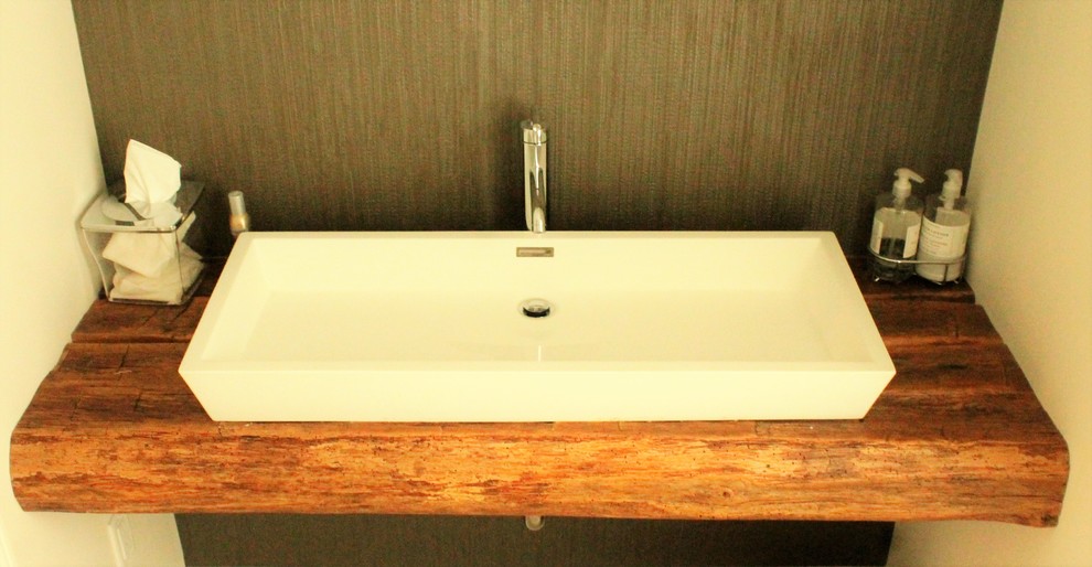 Immagine di un bagno di servizio stile rurale di medie dimensioni con pareti beige, lavabo a bacinella, top in legno, piastrelle nere e piastrelle in gres porcellanato