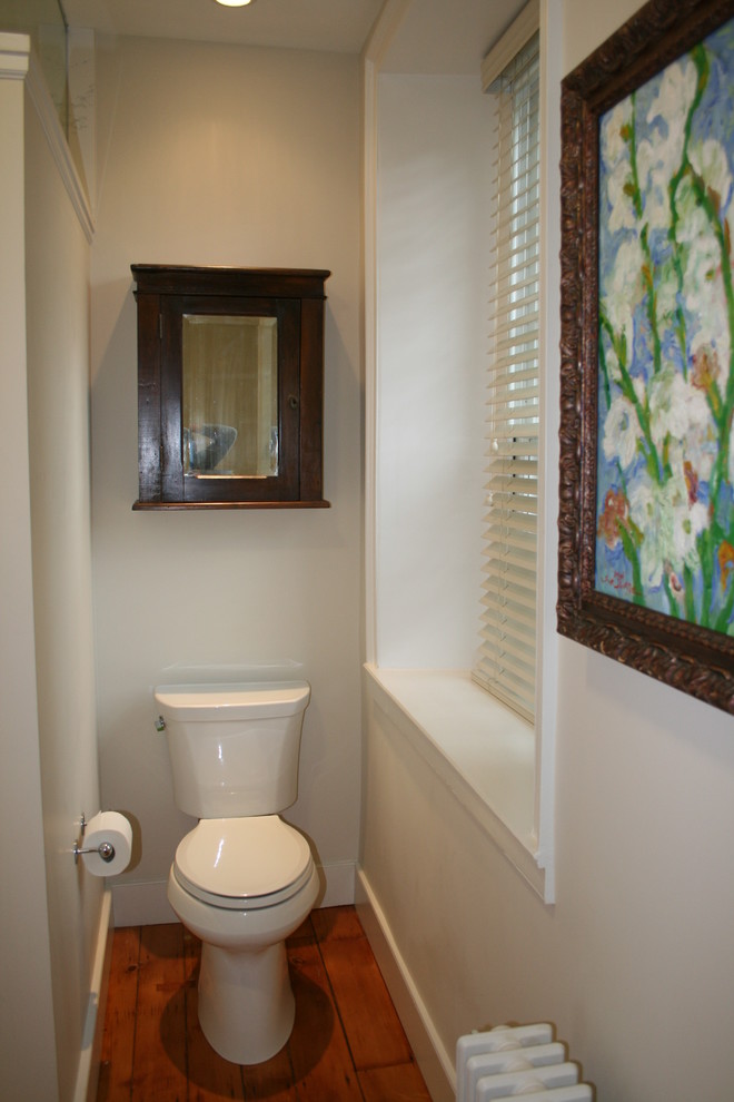 Kleine Klassische Gästetoilette mit Wandtoilette mit Spülkasten, weißer Wandfarbe und braunem Holzboden in Philadelphia