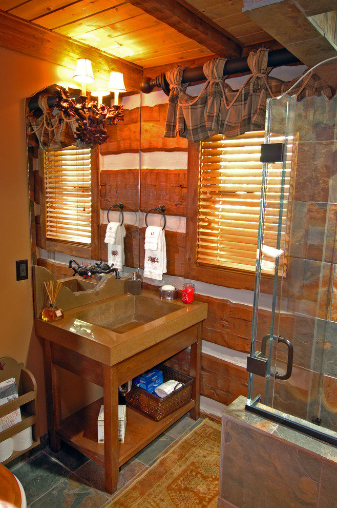 他の地域にあるおしゃれなトイレ・洗面所 (コンクリートの洗面台、石タイル、スレートの床) の写真