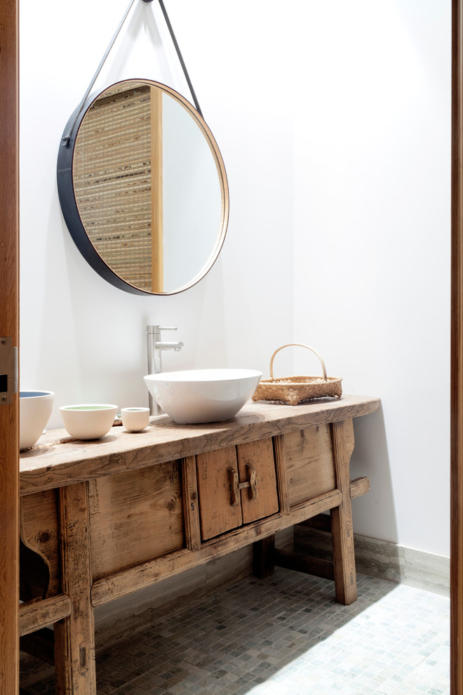 Cette photo montre un WC et toilettes asiatique en bois clair avec une vasque, un placard en trompe-l'oeil, un plan de toilette en bois, un mur blanc et un plan de toilette marron.