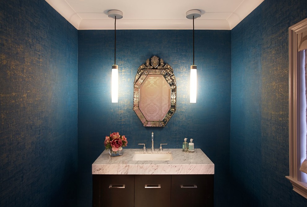 Ejemplo de aseo tradicional renovado de tamaño medio con lavabo bajoencimera, armarios con paneles lisos, puertas de armario de madera en tonos medios, encimera de mármol y paredes azules
