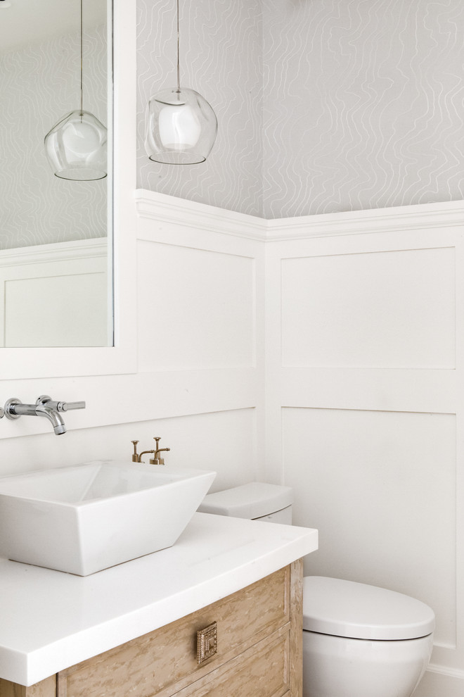 Inspiration pour un WC et toilettes marin en bois clair avec un placard en trompe-l'oeil, un mur gris, une vasque et un plan de toilette blanc.