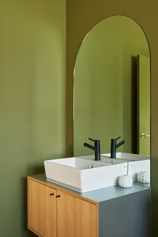 Источник вдохновения для домашнего уюта: туалет в современном стиле с плоскими фасадами, светлыми деревянными фасадами, зелеными стенами, настольной раковиной и синей столешницей