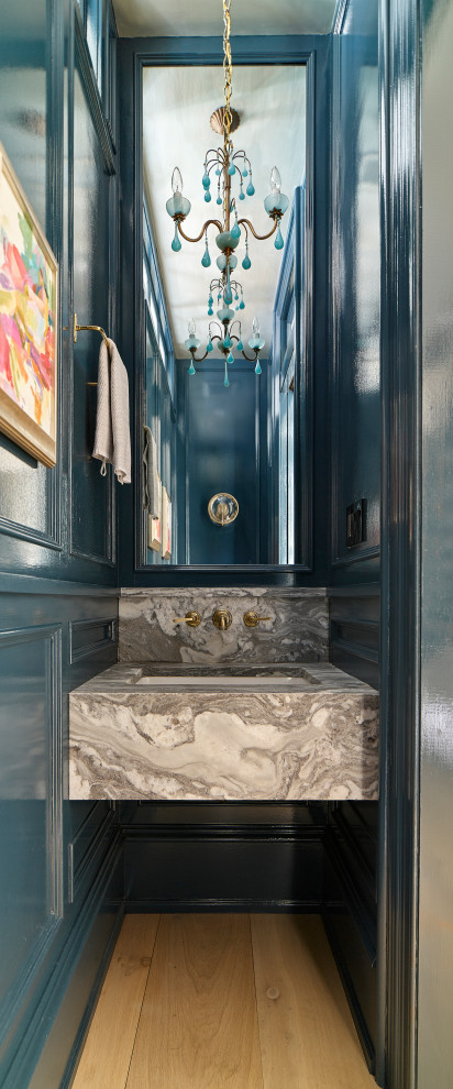 На фото: туалет в стиле неоклассика (современная классика) с синими стенами, паркетным полом среднего тона, врезной раковиной, коричневым полом, серой столешницей, подвесной тумбой и панелями на части стены с