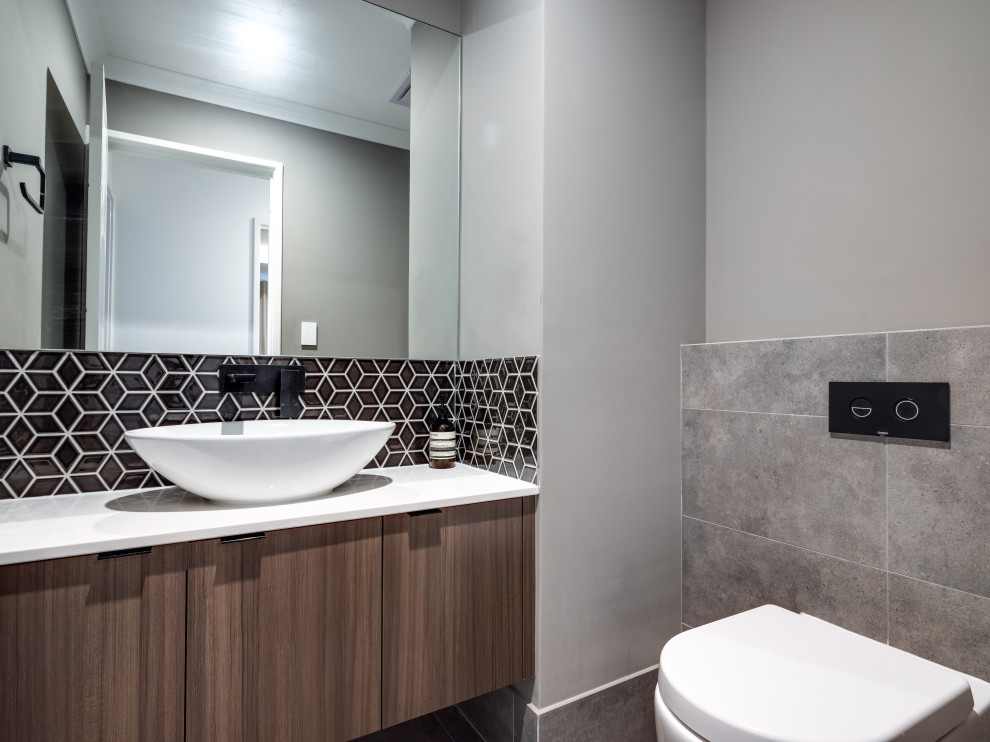 Inspiration for a small modern cloakroom in Perth with a two-piece toilet, grey tiles, porcelain tiles, grey walls, porcelain flooring, a vessel sink, engineered stone worktops, grey floors and white worktops.