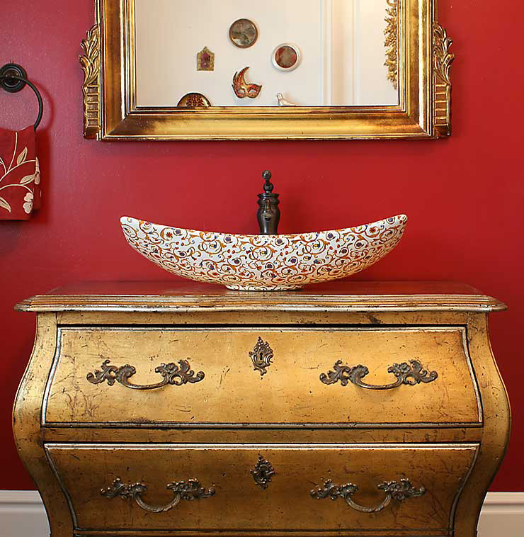Ispirazione per un bagno di servizio boho chic di medie dimensioni con ante con finitura invecchiata, pareti rosse e lavabo a bacinella