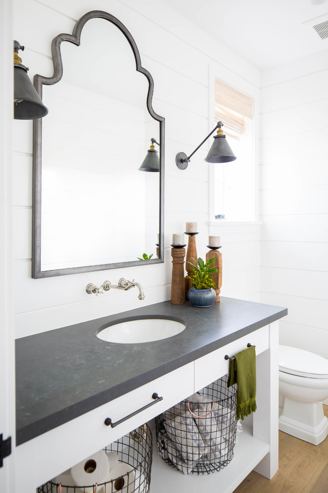Idéer för ett mellanstort lantligt grå toalett, med skåp i shakerstil, vita skåp, vit kakel, vita väggar, mellanmörkt trägolv, ett undermonterad handfat och beiget golv