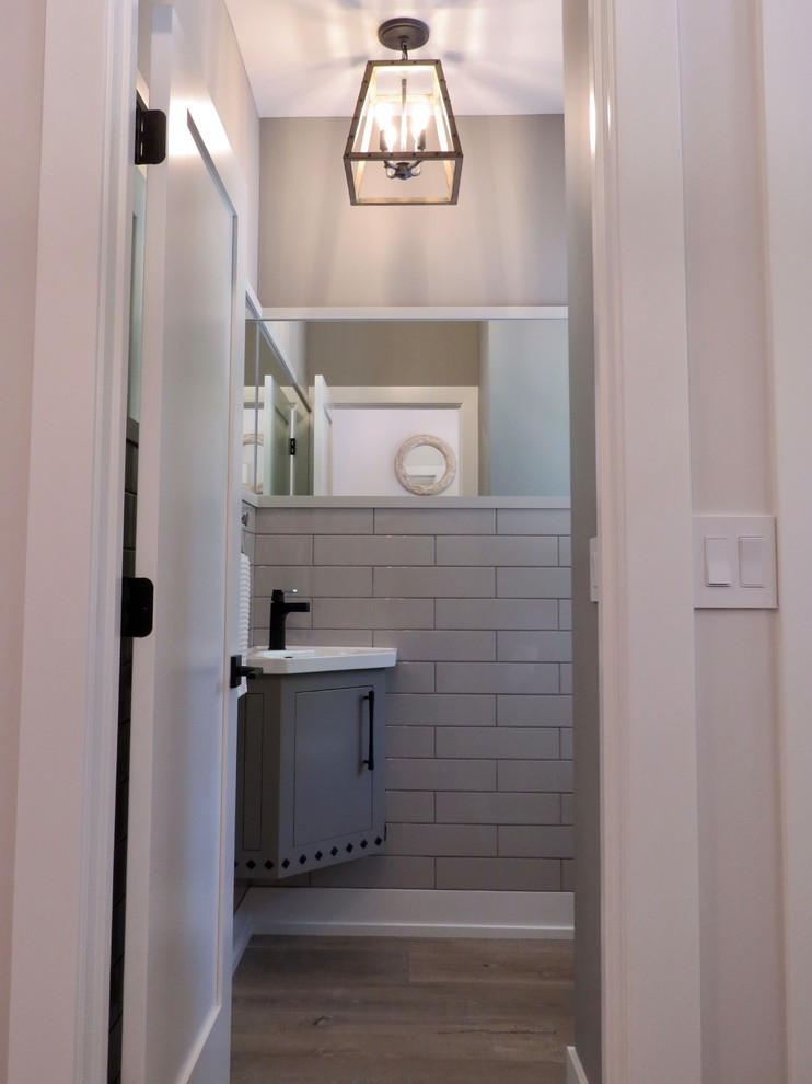小さなインダストリアルスタイルのおしゃれなトイレ・洗面所 (フラットパネル扉のキャビネット、グレーのキャビネット、グレーのタイル、セラミックタイル、グレーの壁、淡色無垢フローリング、一体型シンク、ベージュの床) の写真