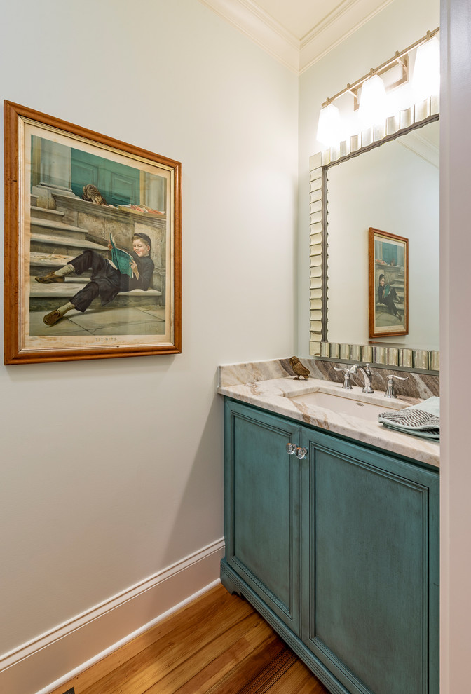 Aménagement d'un petit WC et toilettes classique avec un lavabo encastré, un placard à porte affleurante, des portes de placard bleues, un plan de toilette en marbre, un mur blanc, parquet clair et un plan de toilette beige.