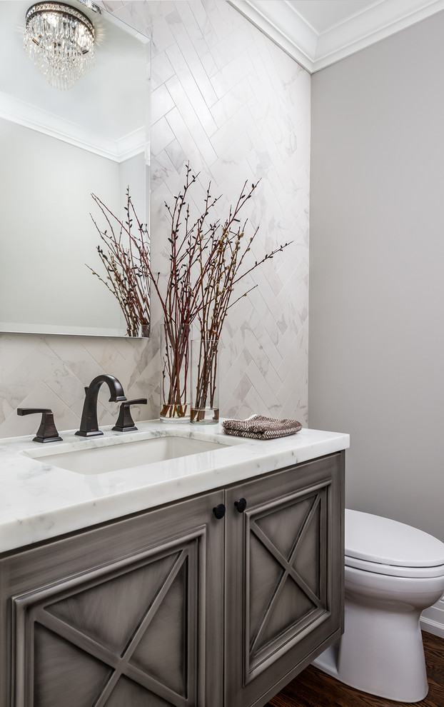 Inspiration for a contemporary cloakroom in Toronto with recessed-panel cabinets, distressed cabinets, grey tiles, stone tiles, a submerged sink, marble worktops, grey walls and medium hardwood flooring.