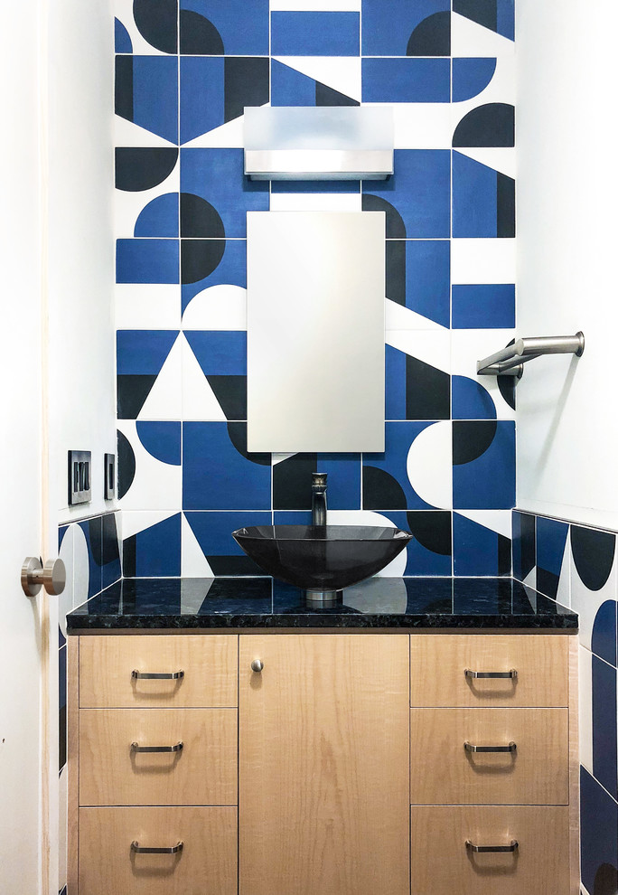 Modern inredning av ett mellanstort svart svart toalett, med släta luckor, skåp i ljust trä, en bidé, blå kakel, cementkakel, vita väggar, mörkt trägolv, ett fristående handfat, granitbänkskiva och brunt golv