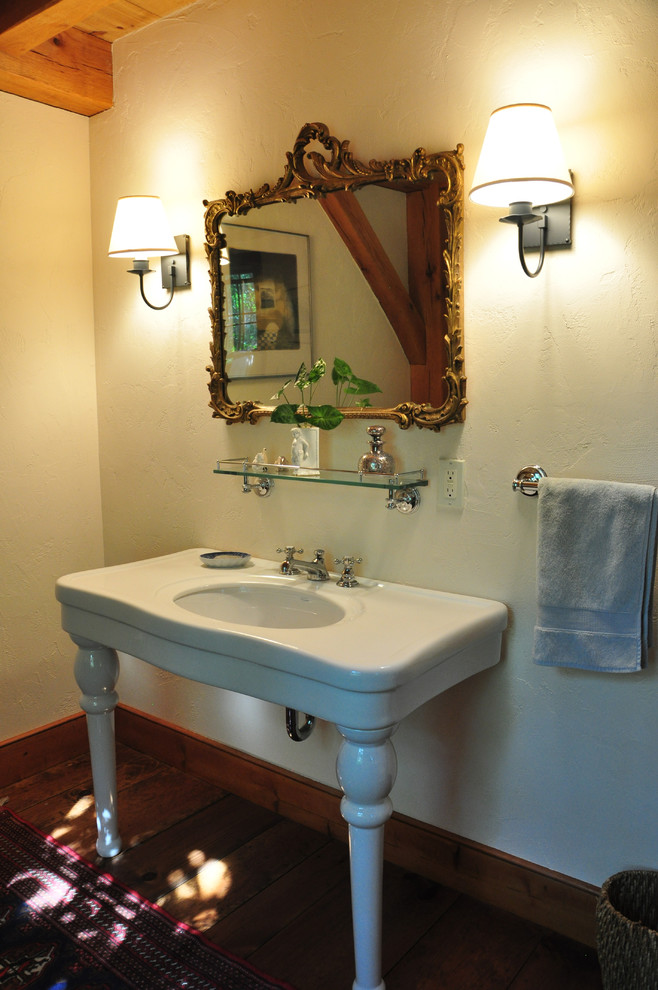 Foto på ett rustikt toalett, med ett konsol handfat, vita väggar och mörkt trägolv