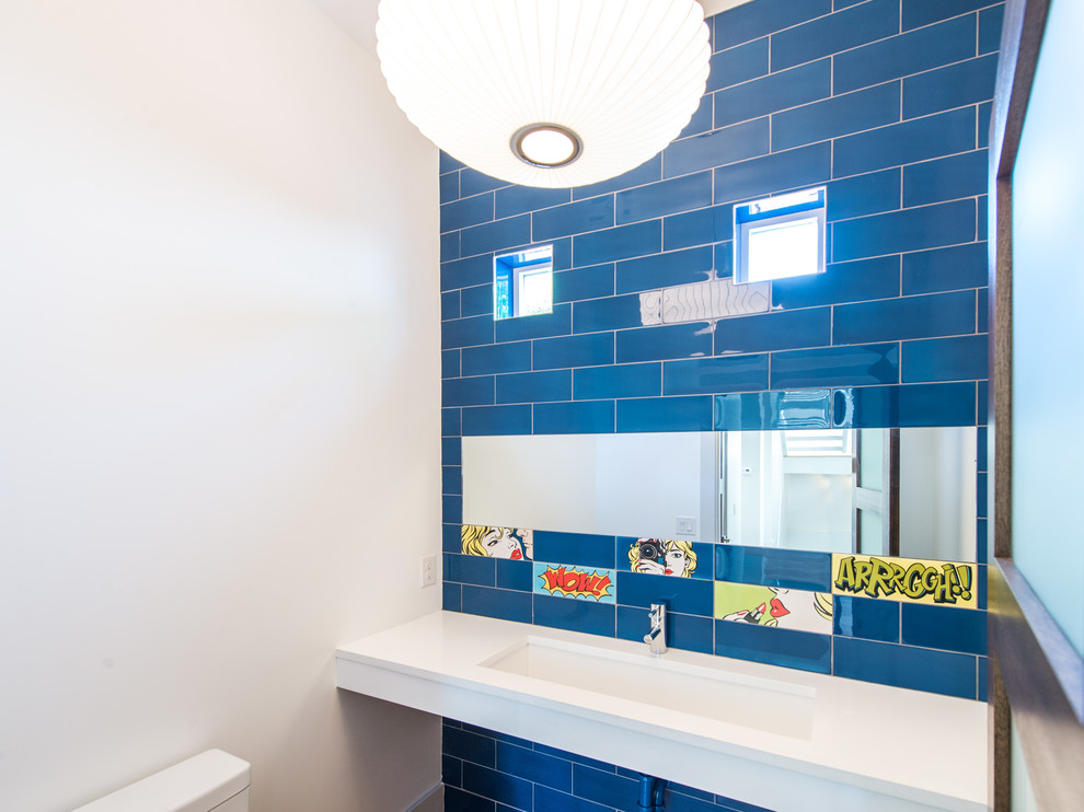 Immagine di un bagno di servizio minimal con piastrelle blu, pareti bianche e lavabo sottopiano