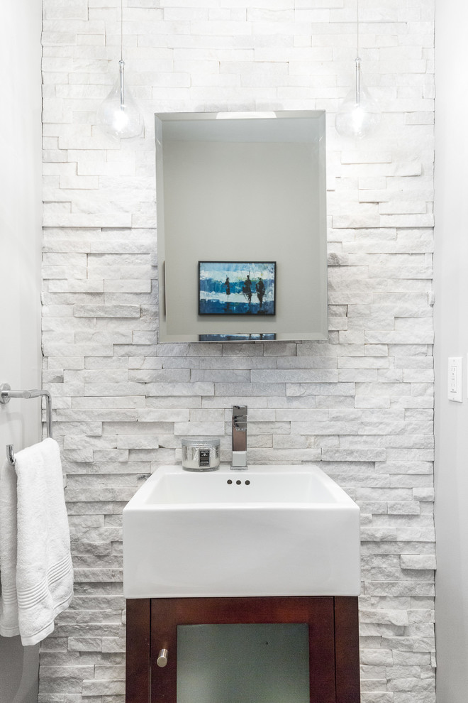 ニューヨークにあるお手頃価格の小さなトランジショナルスタイルのおしゃれなトイレ・洗面所 (ガラス扉のキャビネット、中間色木目調キャビネット、白いタイル、石タイル、白い壁、ベッセル式洗面器) の写真