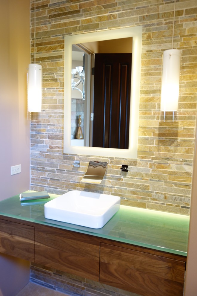 Cette image montre un petit WC et toilettes design en bois brun avec une vasque, un placard à porte plane et un plan de toilette en verre.
