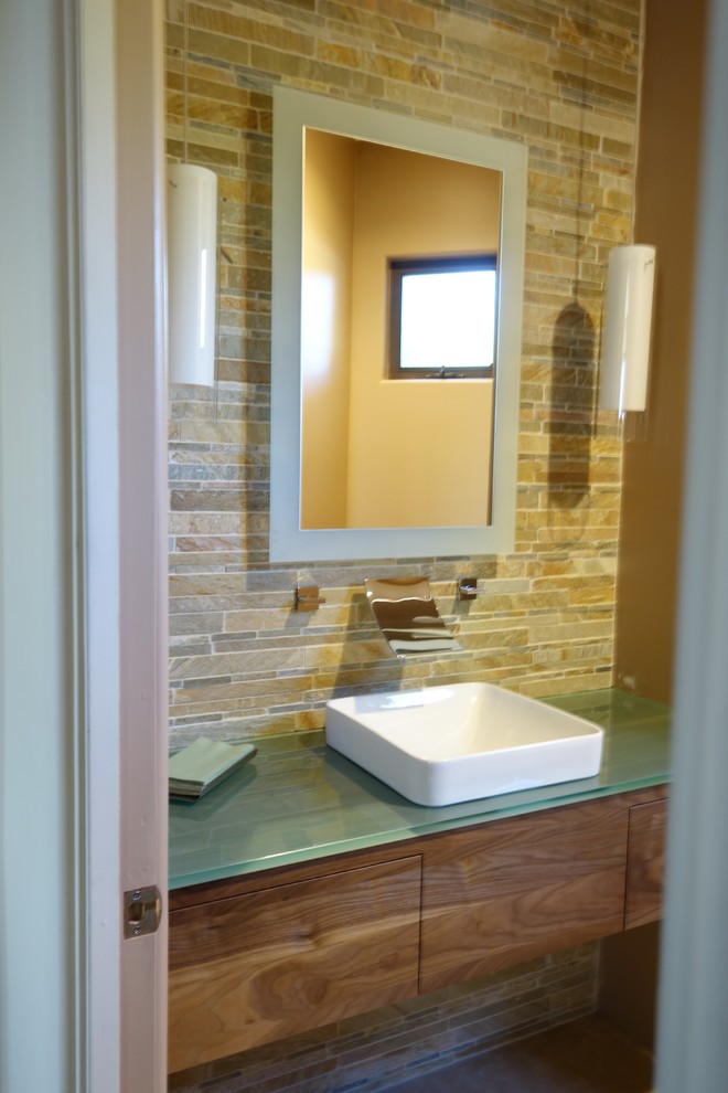 This is an example of a small contemporary cloakroom in Phoenix with a vessel sink, flat-panel cabinets, medium wood cabinets and glass worktops.