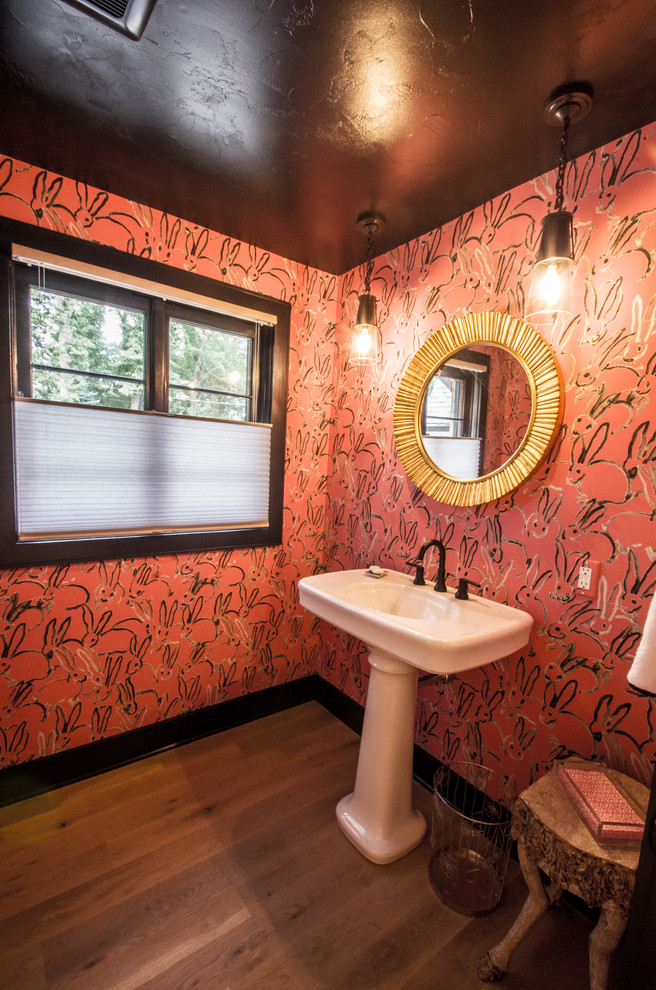 Ejemplo de aseo bohemio grande con sanitario de dos piezas, paredes rosas, suelo de madera en tonos medios, lavabo con pedestal y suelo marrón