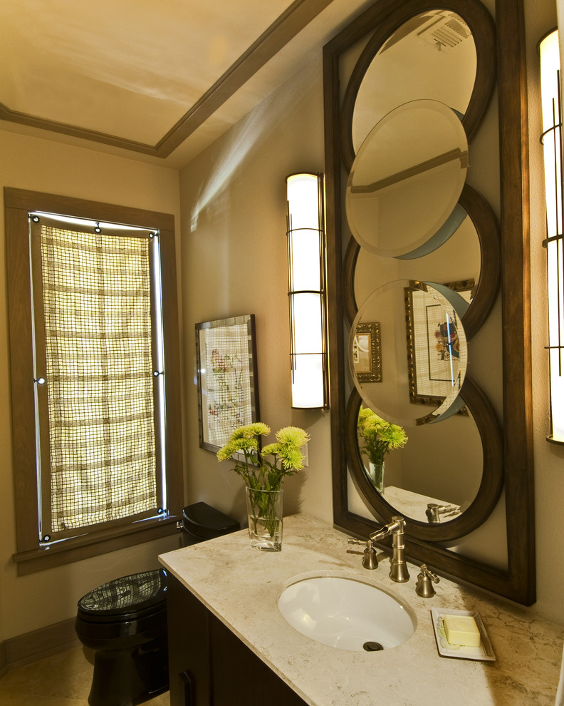 Example of a small arts and crafts travertine floor powder room design in Other with an undermount sink, dark wood cabinets, limestone countertops, a one-piece toilet and beige walls