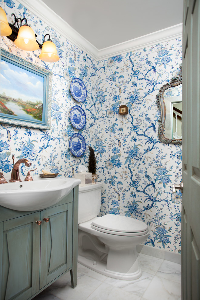 Cette image montre un petit WC et toilettes traditionnel avec un placard avec porte à panneau surélevé, des portes de placard grises, WC séparés, un mur bleu, un sol en marbre, un lavabo posé et un sol gris.