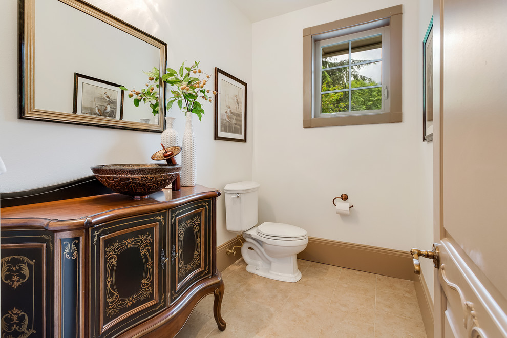Design ideas for a medium sized cloakroom in Seattle with freestanding cabinets, black cabinets, a two-piece toilet, white walls, limestone flooring, a vessel sink, wooden worktops and brown worktops.