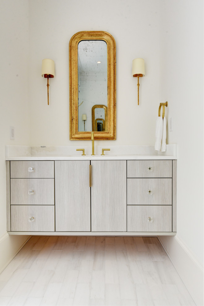 Kleine Moderne Gästetoilette mit flächenbündigen Schrankfronten, grauen Schränken, weißer Waschtischplatte, weißer Wandfarbe, hellem Holzboden und beigem Boden in New Orleans