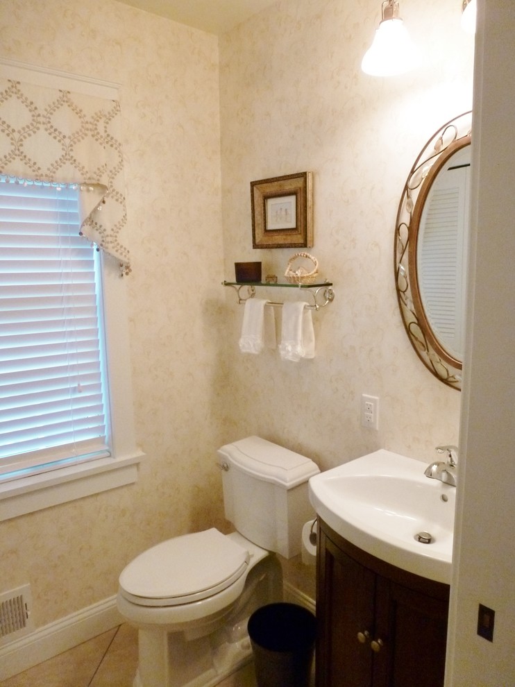 Foto på ett litet vintage toalett, med släta luckor, skåp i mörkt trä, en toalettstol med separat cisternkåpa, beige kakel, klinkergolv i porslin, vita väggar och ett integrerad handfat
