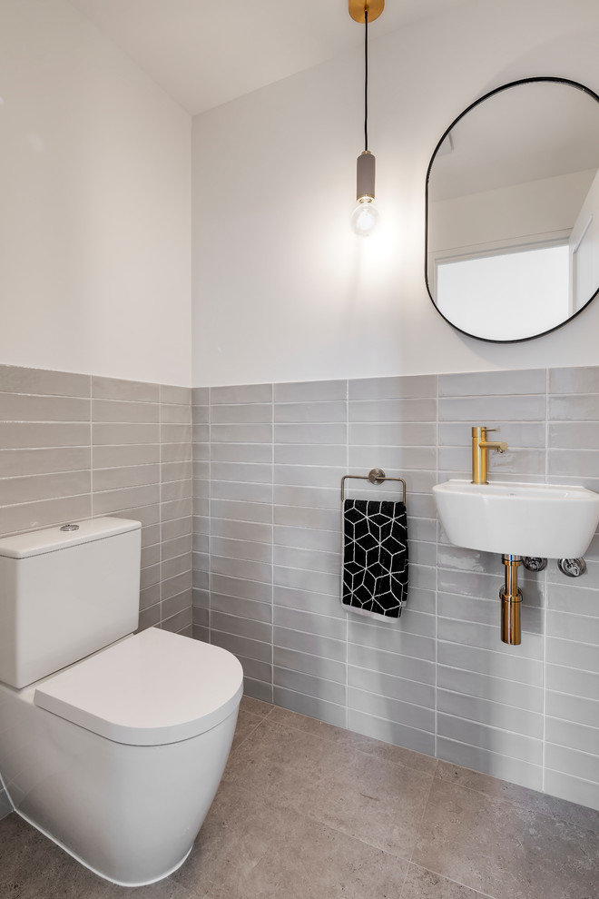 Inspiration för moderna toaletter, med grå kakel, vita väggar, ett väggmonterat handfat och grått golv