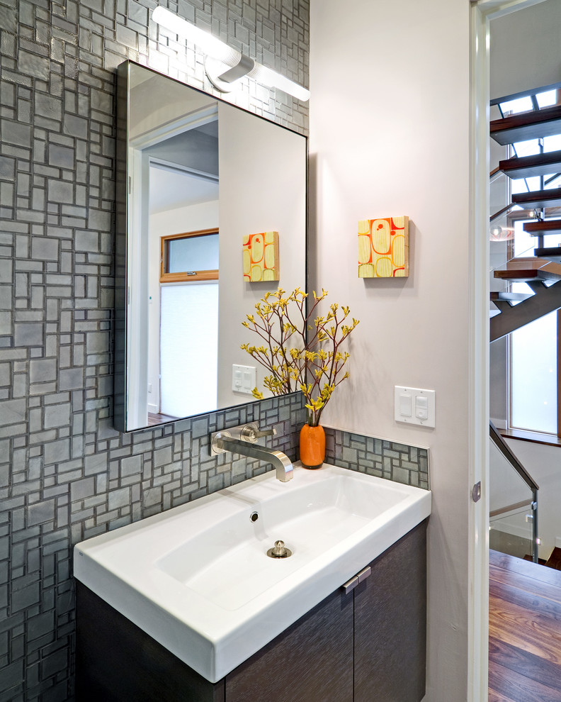На фото: туалет в современном стиле с монолитной раковиной и серой плиткой