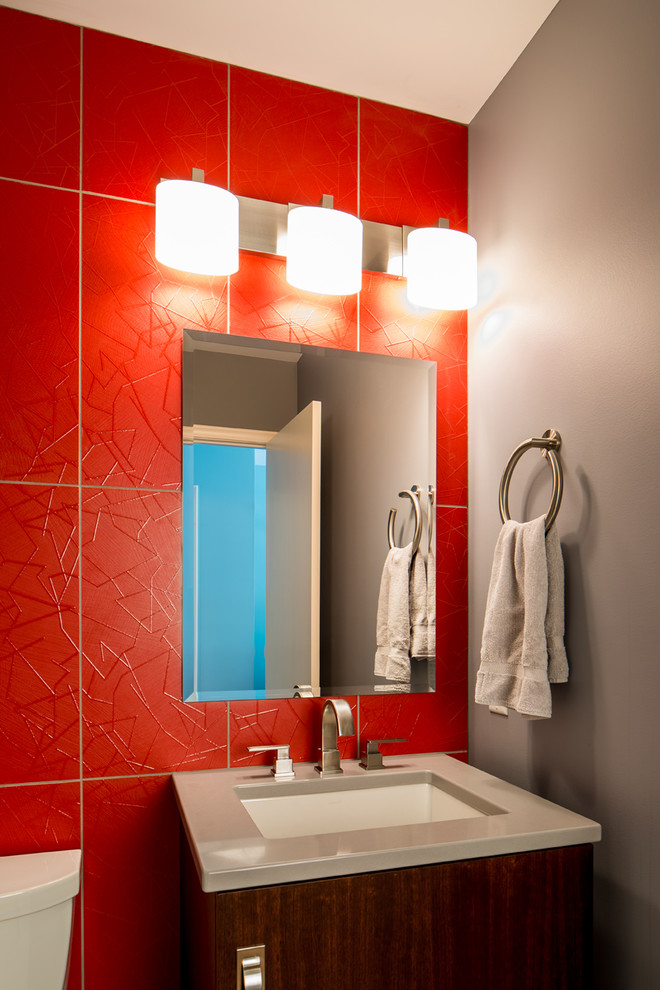 This is an example of a medium sized contemporary cloakroom in Minneapolis with a submerged sink, flat-panel cabinets, medium wood cabinets, solid surface worktops, red tiles, porcelain tiles and red walls.