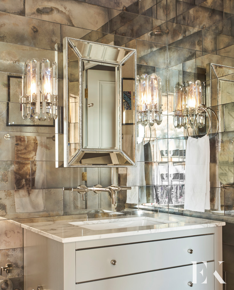 Idee per un bagno di servizio tradizionale di medie dimensioni con consolle stile comò, ante grigie, piastrelle a specchio, lavabo sottopiano, top in marmo e top bianco