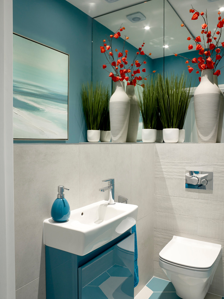 Small trendy beige tile and ceramic tile powder room photo in London with flat-panel cabinets, turquoise cabinets, a wall-mount toilet and an integrated sink