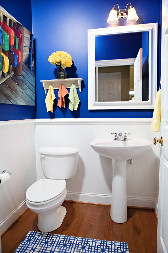 На фото: туалет среднего размера в морском стиле с раковиной с пьедесталом, раздельным унитазом, синими стенами, паркетным полом среднего тона и коричневым полом