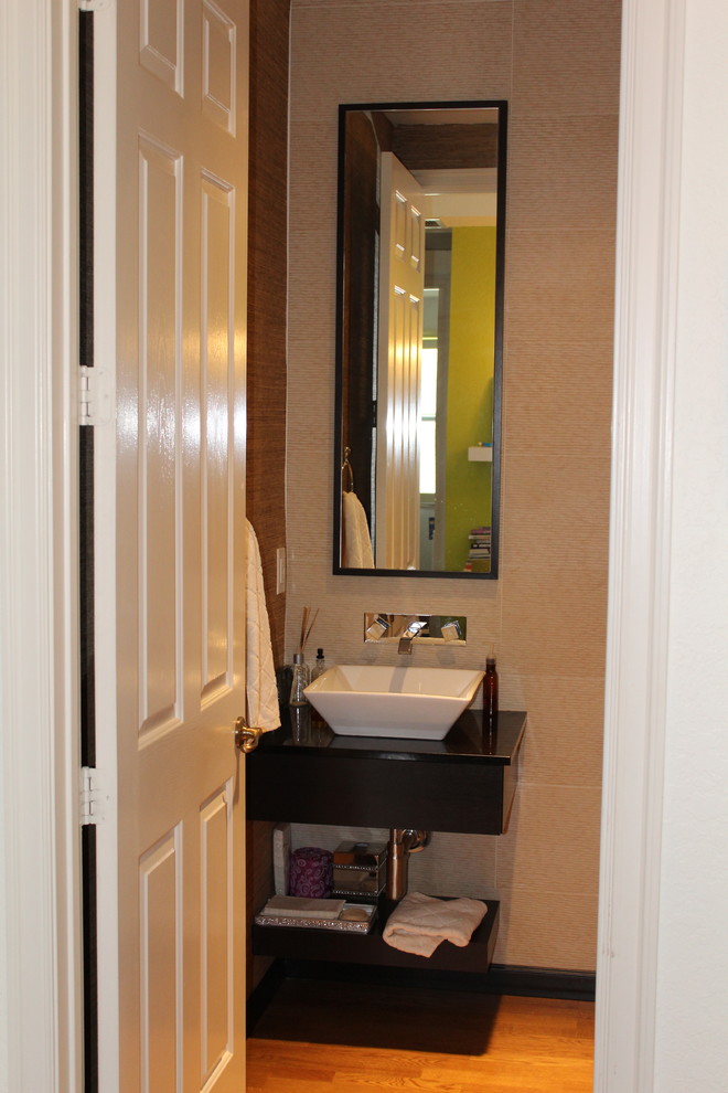 Esempio di un piccolo bagno di servizio minimal con ante nere, pareti beige, pavimento in legno massello medio, lavabo a bacinella e top in legno