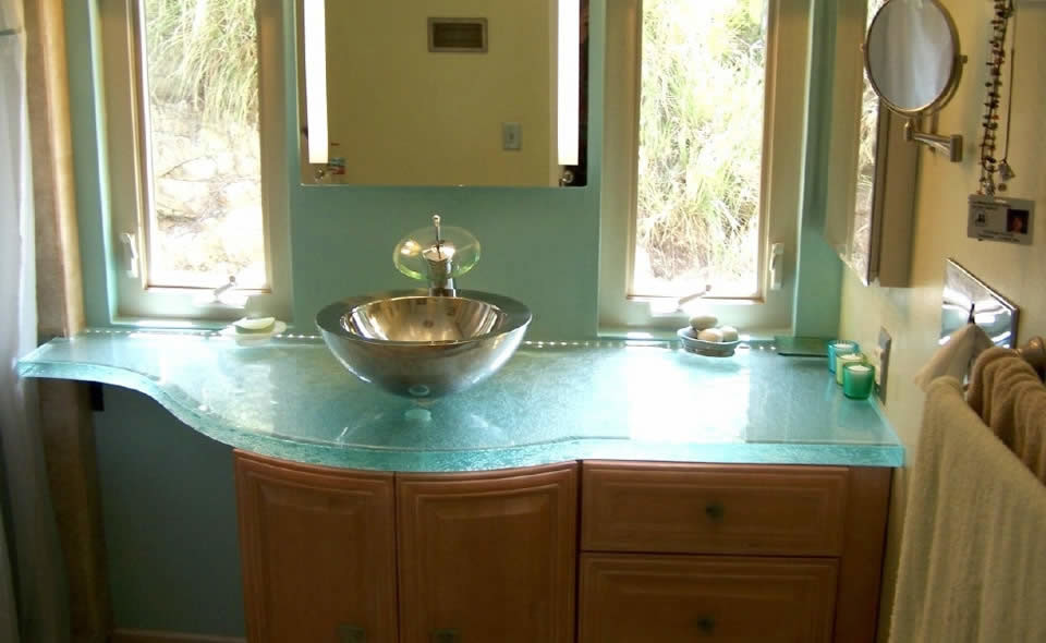 Ispirazione per un piccolo bagno di servizio con top in vetro, ante con bugna sagomata, ante in legno scuro e lavabo a bacinella