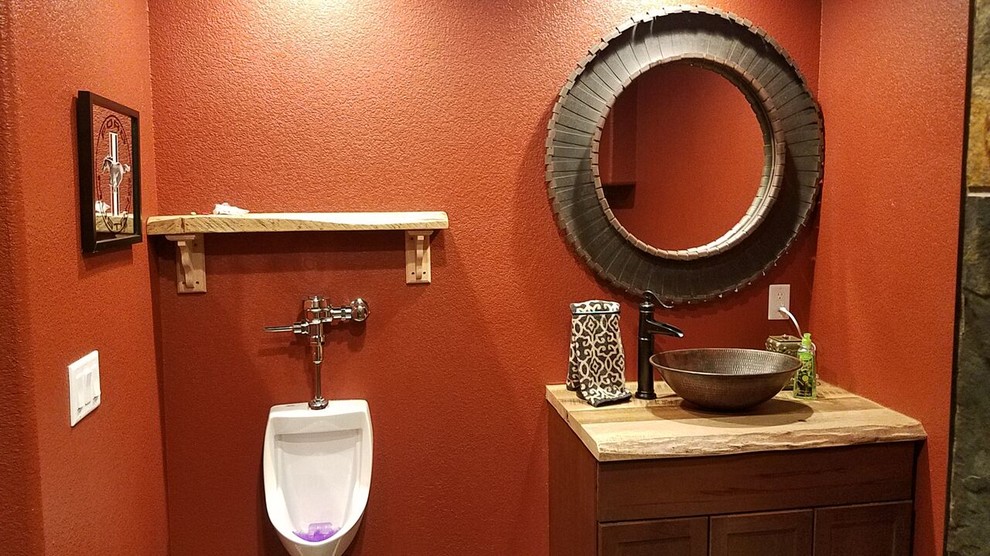 Inspiration for a small rustic powder room remodel in Denver with shaker cabinets, dark wood cabinets, an urinal, red walls, a vessel sink and wood countertops