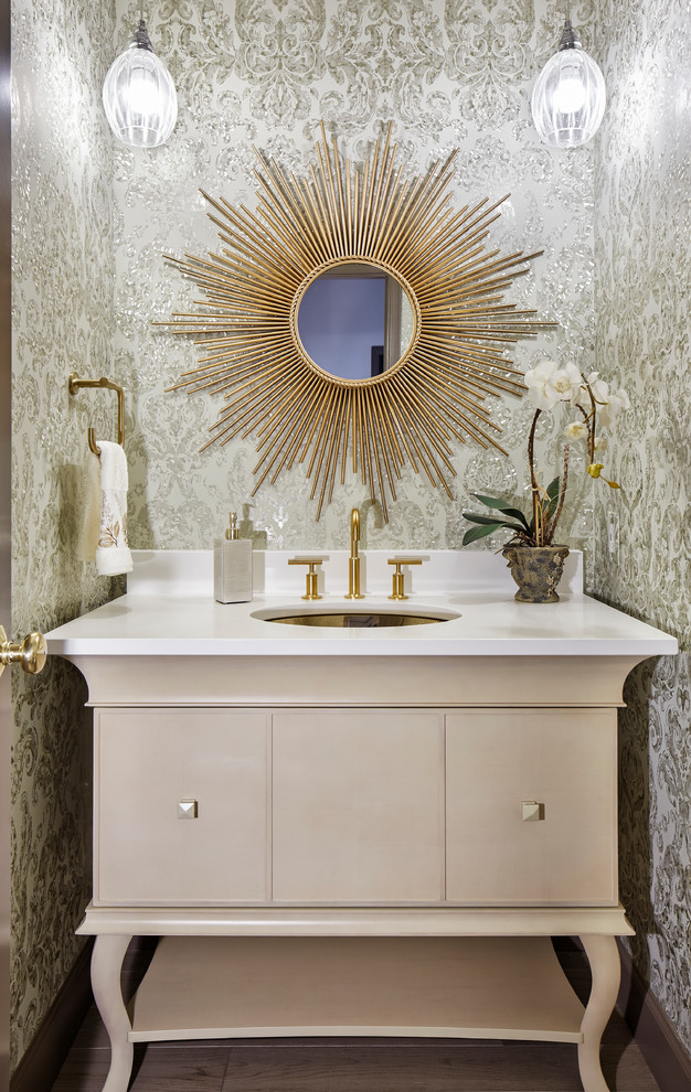 Foto på ett litet vintage vit toalett, med ett undermonterad handfat, möbel-liknande, beige skåp och flerfärgade väggar