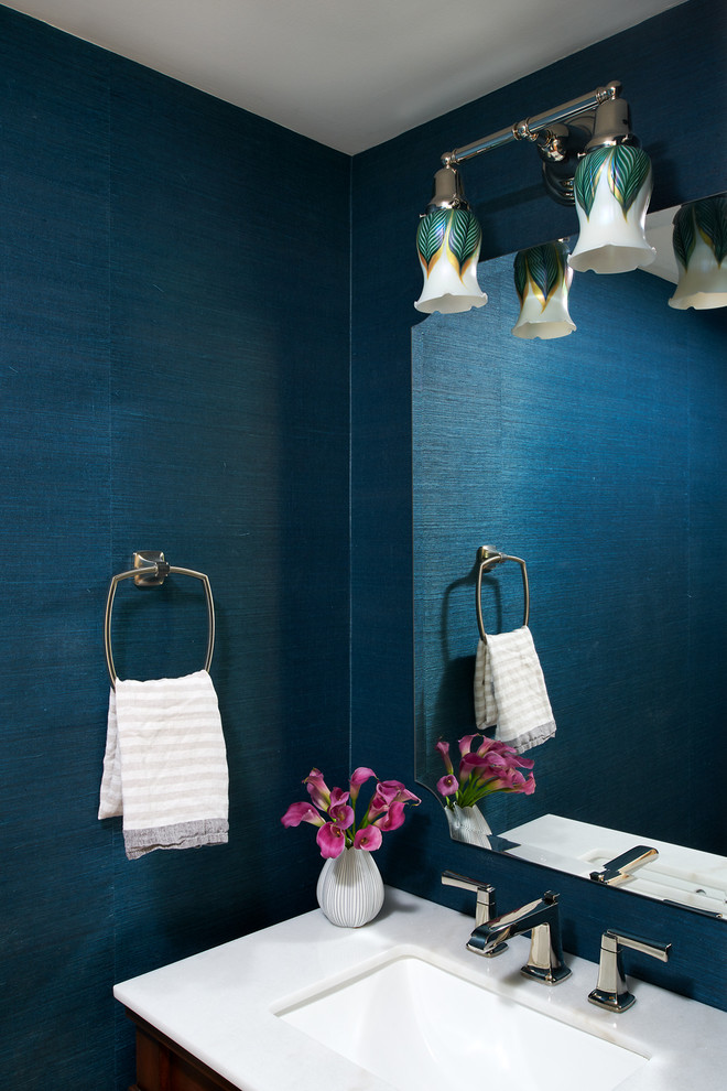 Idee per un piccolo bagno di servizio classico con ante in legno bruno, pareti blu, lavabo sottopiano, top in marmo e top bianco