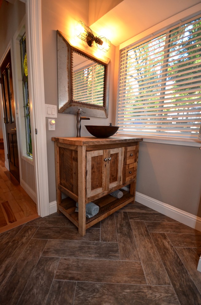 Exemple d'un WC et toilettes craftsman en bois brun de taille moyenne avec un placard en trompe-l'oeil, un mur gris, parquet foncé, une vasque et un plan de toilette en bois.