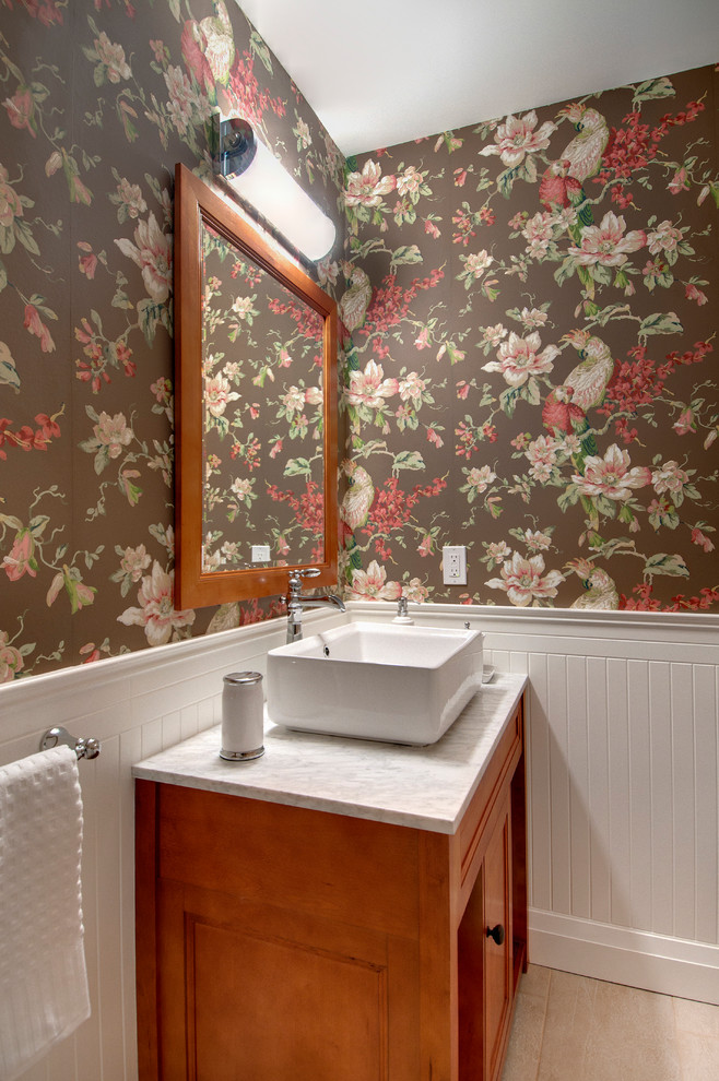 На фото: туалет в классическом стиле с настольной раковиной, фасадами цвета дерева среднего тона и белой столешницей
