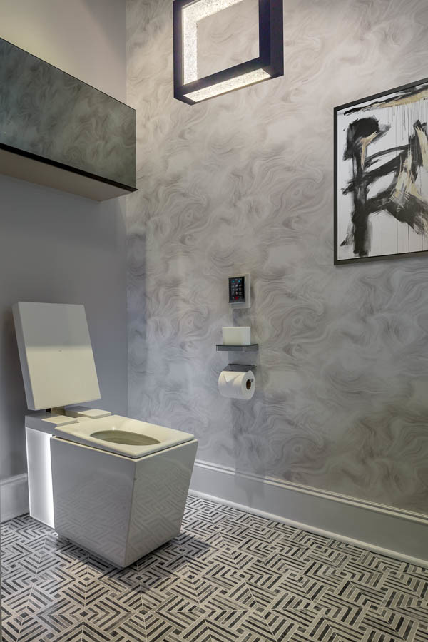 Exemple d'un petit WC et toilettes moderne avec un placard en trompe-l'oeil, des portes de placard blanches, un bidet, un carrelage noir et blanc, du carrelage en marbre, un sol en marbre, un lavabo intégré et un plan de toilette en calcaire.