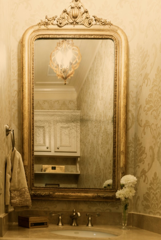 Klassisk inredning av ett litet toalett, med ett undermonterad handfat, vita skåp, marmorbänkskiva, en toalettstol med hel cisternkåpa, klinkergolv i keramik, släta luckor och beige väggar